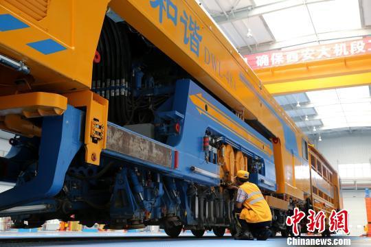 圖為工人正在清理大型養(yǎng)路機(jī)械?！堖h(yuǎn) 攝